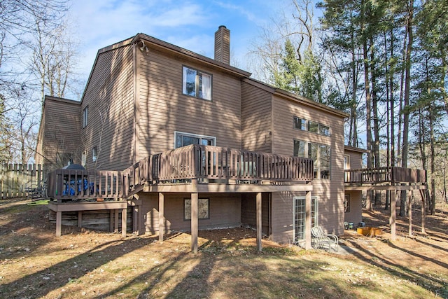 back of house featuring a wooden deck and a chimney