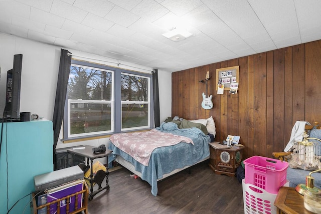 bedroom featuring wooden walls and wood finished floors