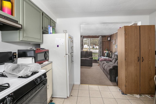 kitchen featuring light tile patterned floors, green cabinetry, black microwave, gas range, and open floor plan