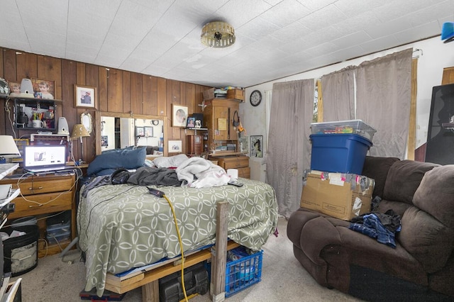 carpeted bedroom featuring wooden walls