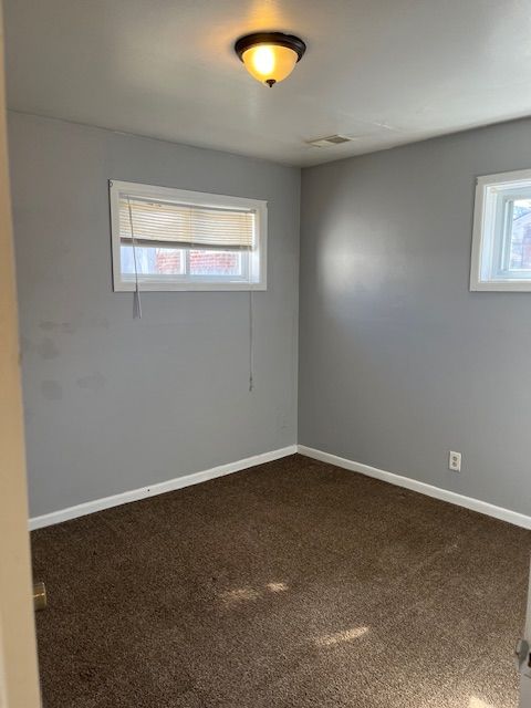 spare room with visible vents, baseboards, and carpet flooring