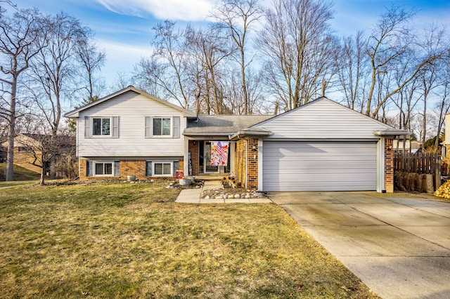 tri-level home featuring a front lawn, fence, concrete driveway, an attached garage, and brick siding