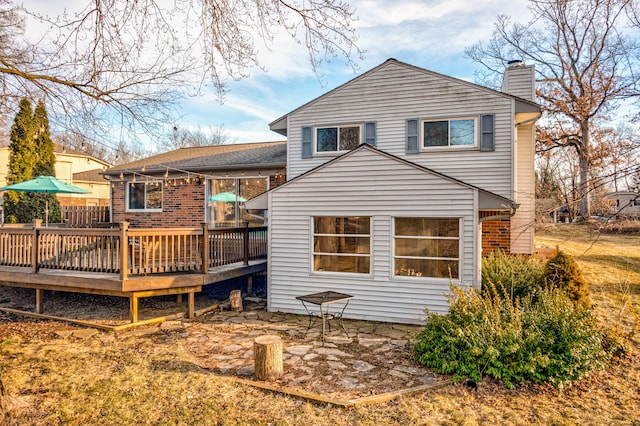 back of house with a deck and a chimney