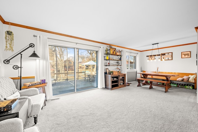 living area with visible vents, carpet floors, and ornamental molding