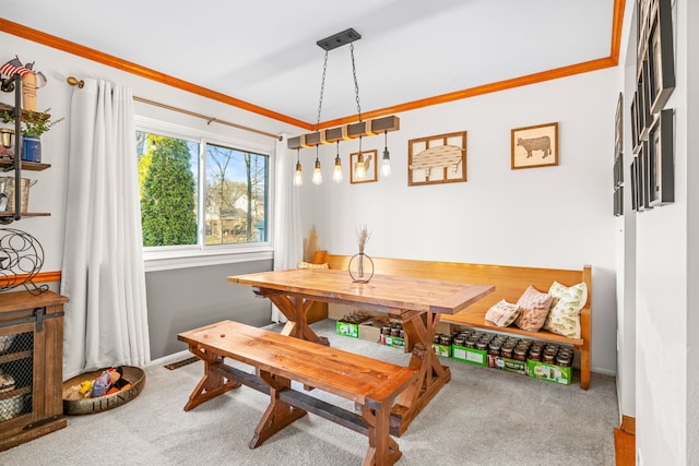 carpeted dining space featuring crown molding, baseboards, and breakfast area