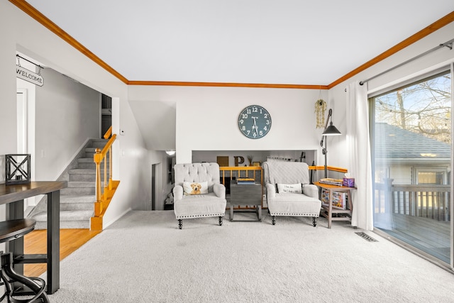 sitting room featuring stairway, visible vents, carpet floors, and ornamental molding