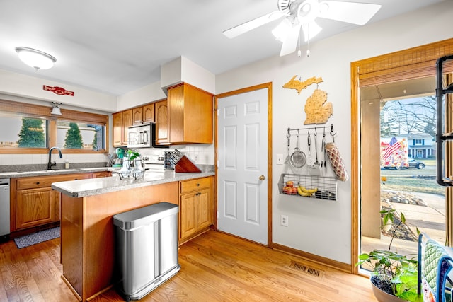 kitchen featuring stainless steel appliances, light wood-style floors, visible vents, and a healthy amount of sunlight