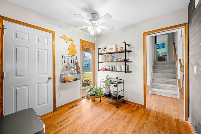 interior space featuring visible vents, baseboards, light wood-style floors, and stairs