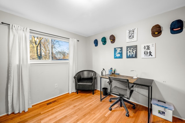 office space with visible vents, baseboards, and wood finished floors