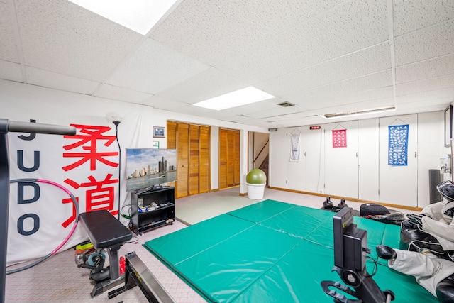 recreation room with a paneled ceiling and carpet floors