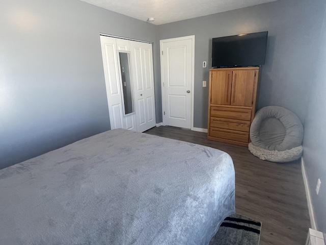 bedroom featuring a closet, baseboards, and dark wood-style floors