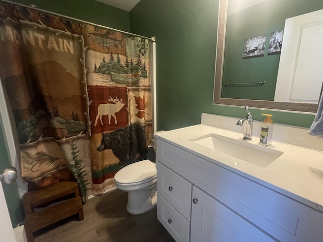 full bath with a shower with curtain, toilet, wood finished floors, and vanity