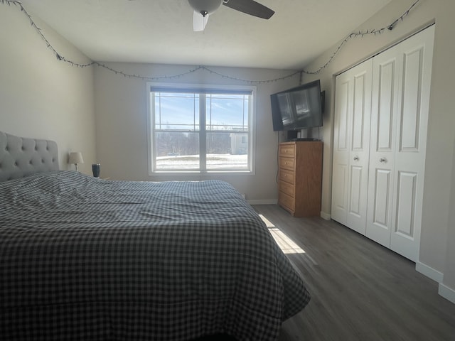 bedroom featuring ceiling fan, a closet, baseboards, and wood finished floors