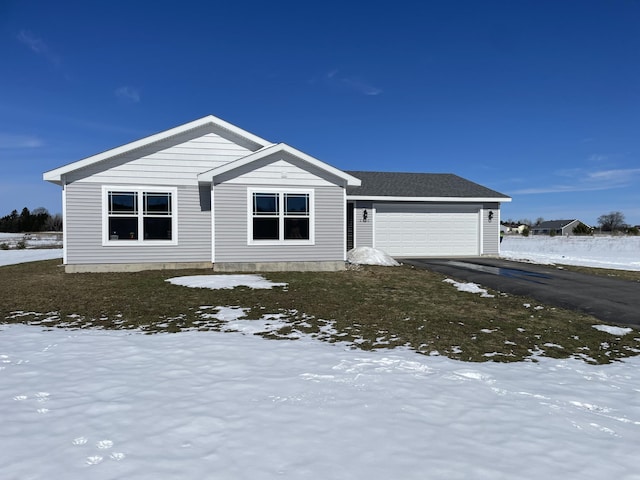 view of front of home featuring an attached garage, a shingled roof, and driveway