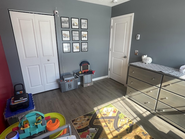 bedroom with a closet, baseboards, and wood finished floors