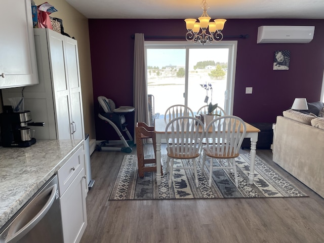 dining area featuring an AC wall unit, wood finished floors, and a chandelier