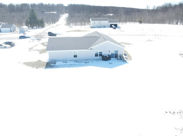 snowy aerial view with a wooded view