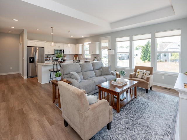 living room featuring recessed lighting, baseboards, and wood finished floors