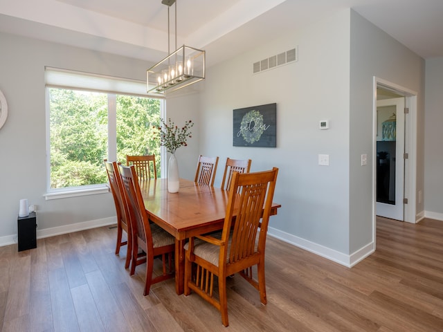 dining room featuring visible vents, baseboards, and wood finished floors