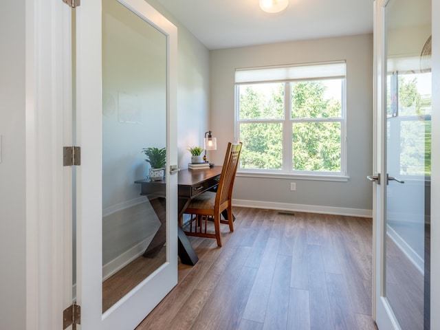 office area with visible vents, baseboards, wood finished floors, and french doors