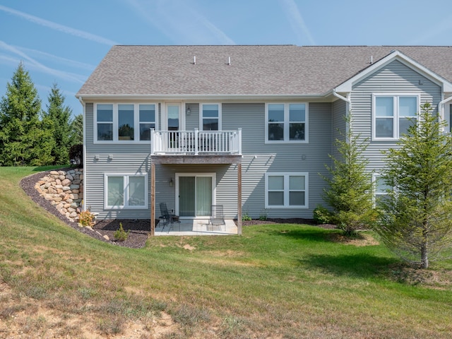 back of house with a patio, a lawn, and roof with shingles