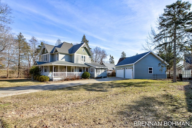 view of side of home featuring fence, a porch, a yard, an outdoor structure, and a garage