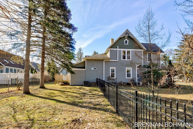 back of property featuring central AC unit, a lawn, a chimney, and a fenced backyard