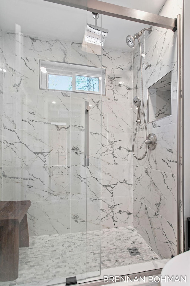 full bathroom with a marble finish shower