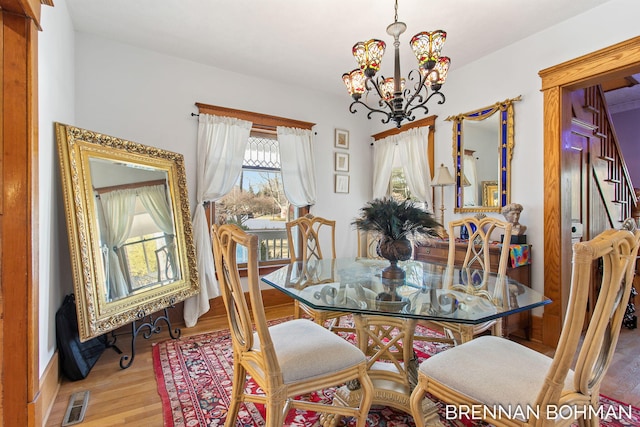 dining area featuring a chandelier, visible vents, and wood finished floors