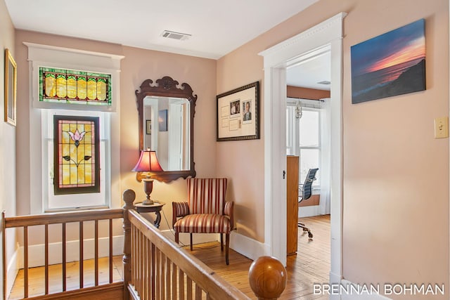 living area with visible vents, baseboards, and wood finished floors