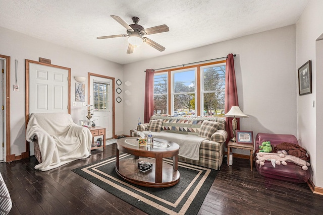 living room with ceiling fan, baseboards, a textured ceiling, and hardwood / wood-style floors