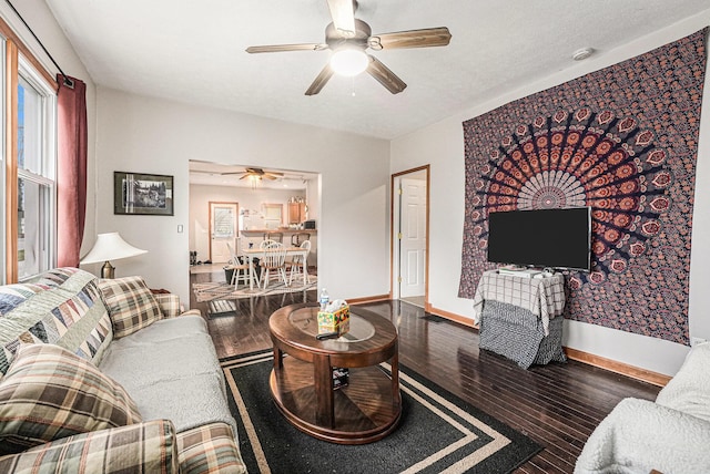 living area featuring ceiling fan, baseboards, and wood finished floors