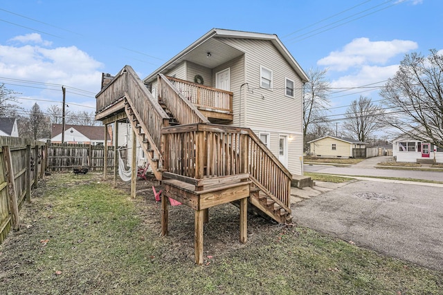 back of house featuring a wooden deck, stairs, and fence