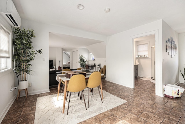 dining space with an AC wall unit and baseboards