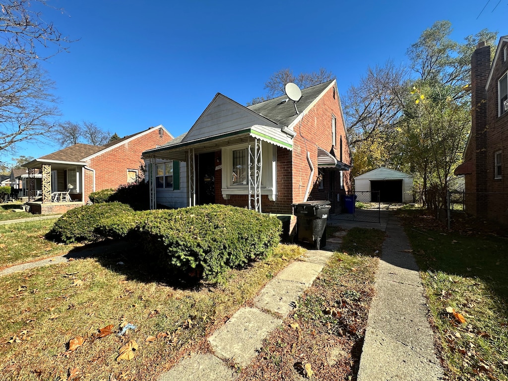 view of front of property with an outbuilding, brick siding, and driveway