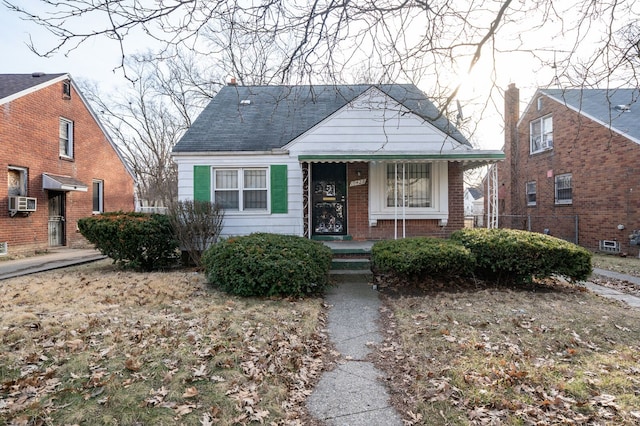 bungalow with cooling unit and a porch