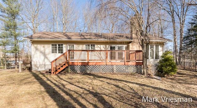 back of house featuring a lawn and a deck