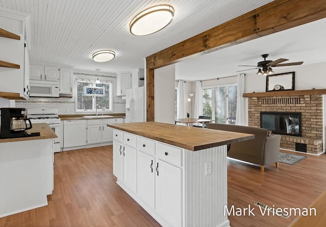 kitchen with open shelves, white appliances, butcher block counters, and white cabinetry