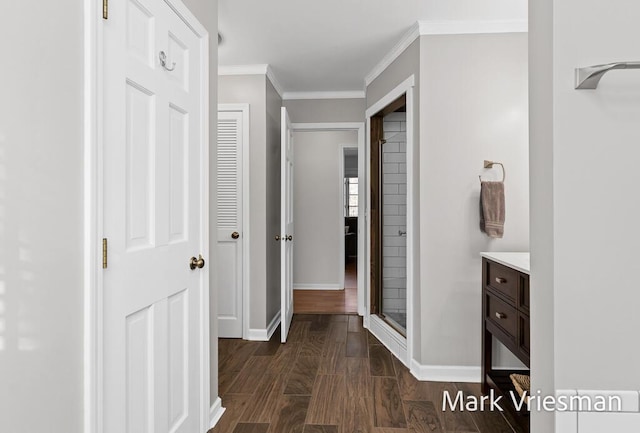 hallway featuring baseboards, dark wood-type flooring, and crown molding