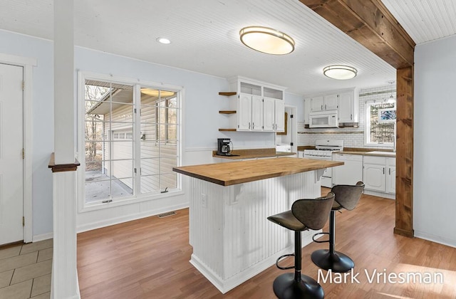 kitchen with wooden counters, white cabinetry, open shelves, and white appliances