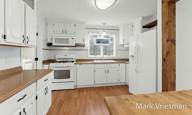 kitchen featuring white cabinetry, white appliances, light wood-type flooring, and a sink