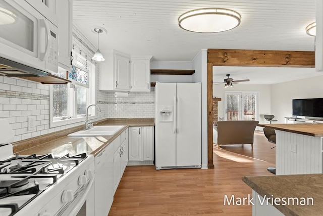 kitchen with decorative light fixtures, light wood-type flooring, white cabinets, white appliances, and a sink