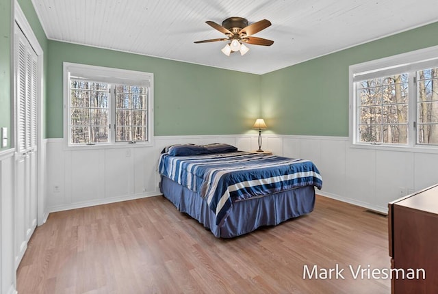 bedroom featuring multiple windows, visible vents, and wainscoting