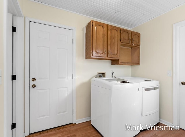 laundry room featuring washing machine and clothes dryer, baseboards, wooden ceiling, wood finished floors, and cabinet space