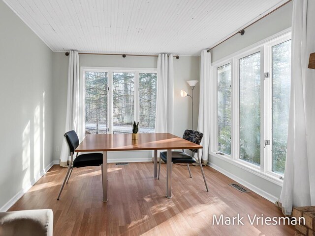 dining space with visible vents, wooden ceiling, baseboards, and wood finished floors