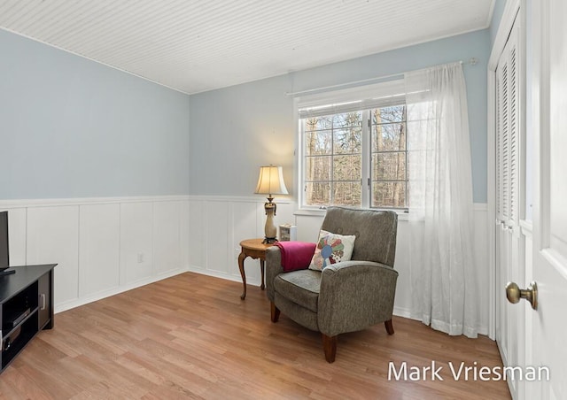 sitting room with wood finished floors and wainscoting