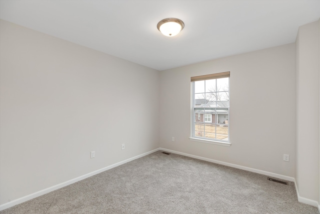 spare room with baseboards, carpet flooring, and visible vents