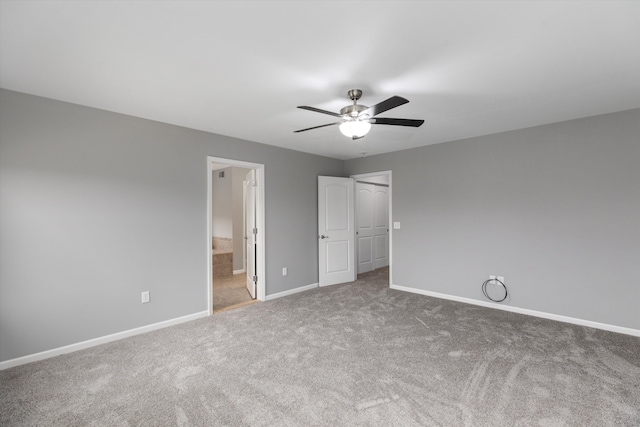 unfurnished bedroom featuring connected bathroom, baseboards, carpet flooring, and a ceiling fan