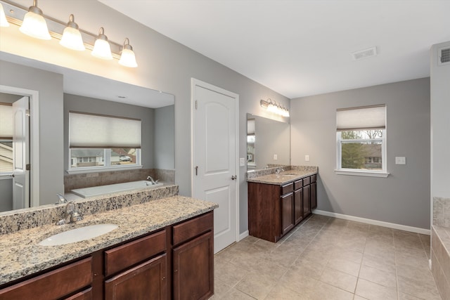 bathroom featuring a bath, baseboards, visible vents, and vanity