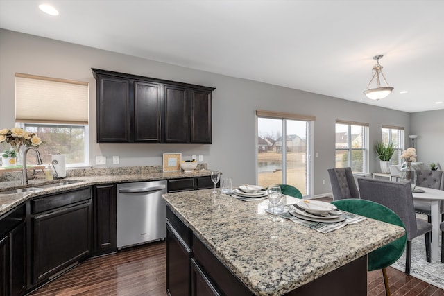 kitchen featuring dark wood-style flooring, a sink, light stone counters, and dishwasher